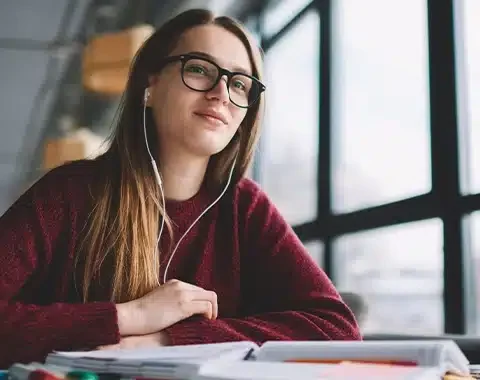 Studentte met oortjes in achter een boek Studentte met oortjes in achter een boek